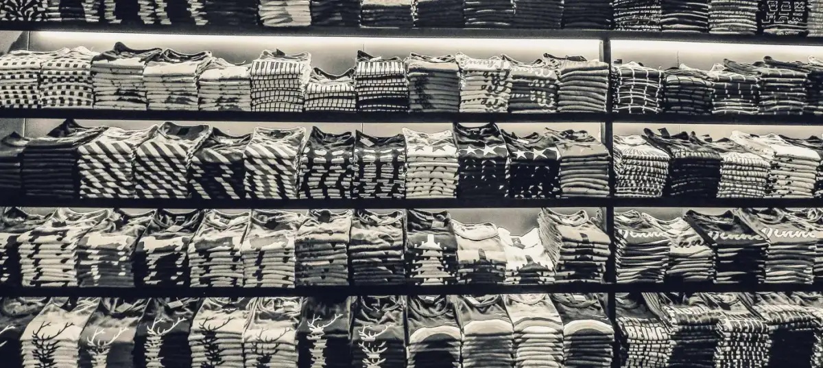 Neatly folded branded shirts stacked on shelves