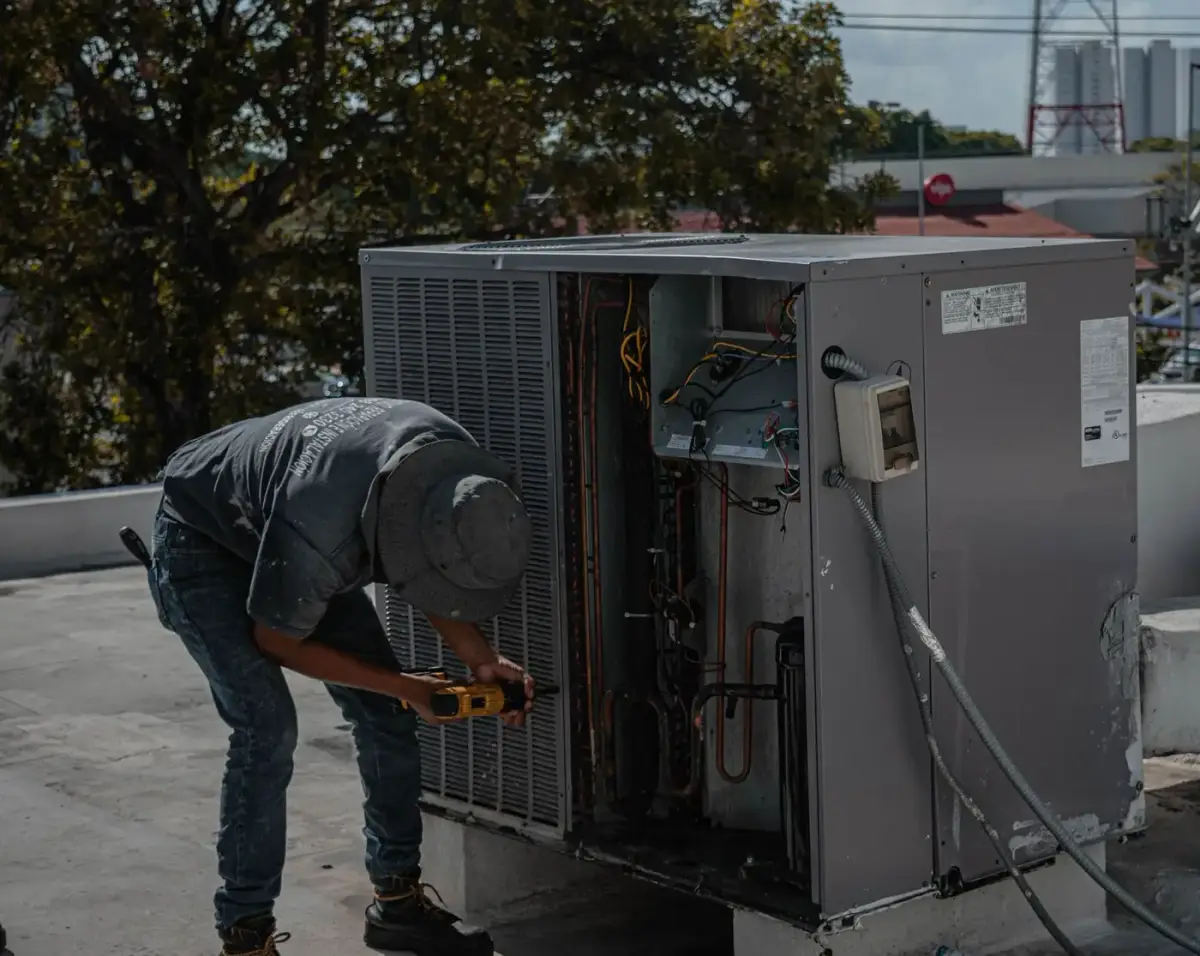 An HVAC technician servicing a rooftop air conditioning unit