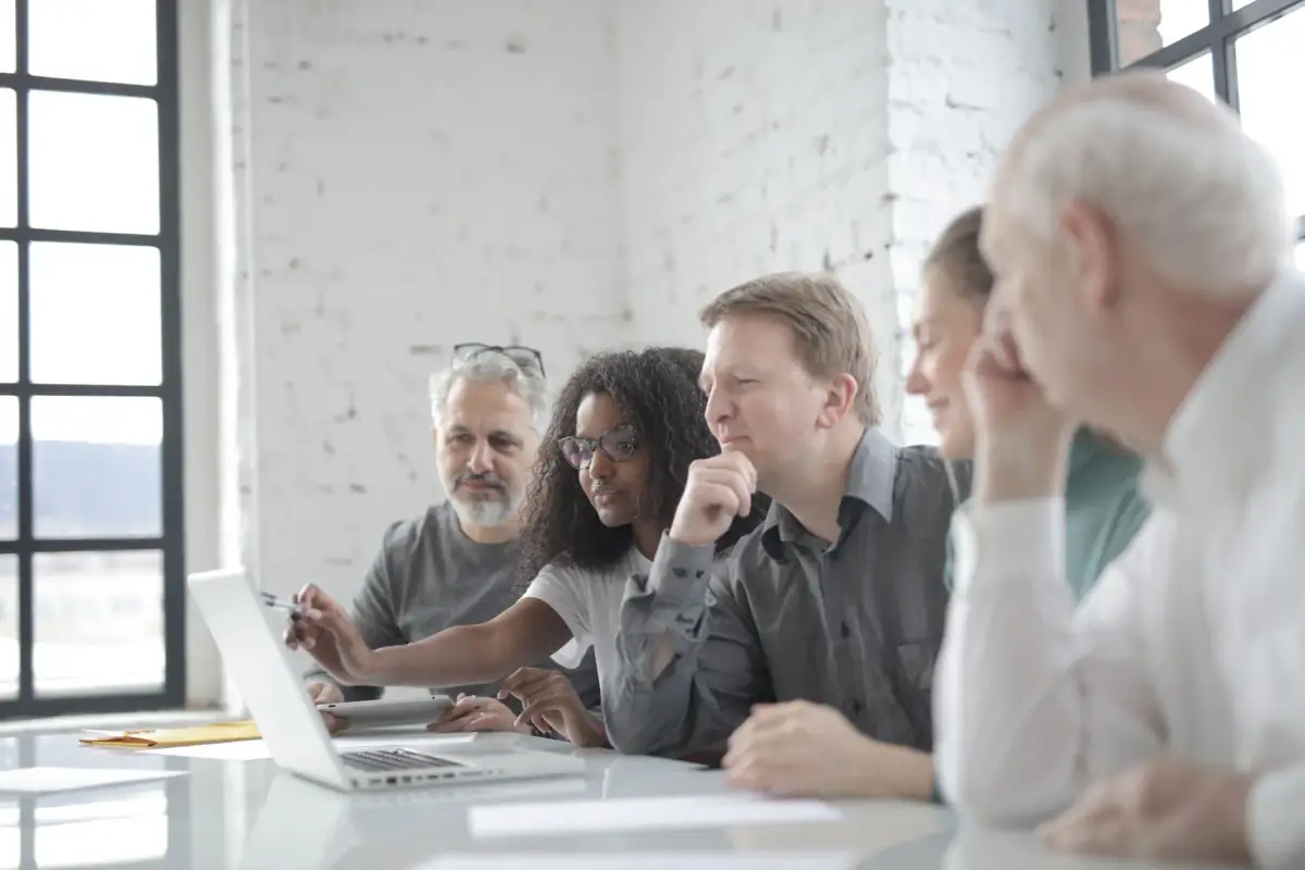 A team reviewing a plan together around a laptop