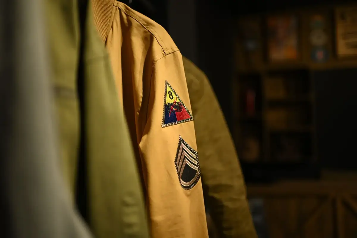 A jacket sleeve showing several stitched embroidered patches