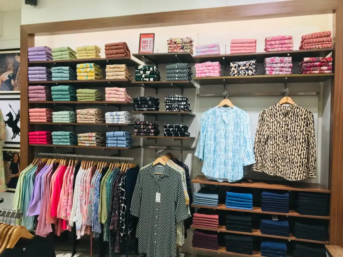 A retail apparel store with racks and shelves of clothing