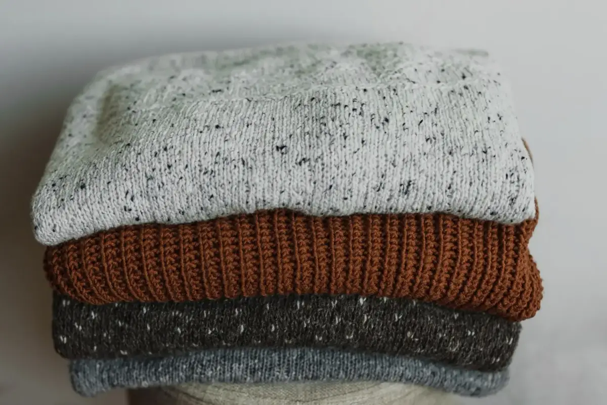 A neat stack of folded sweatshirts and hoodies in school colors