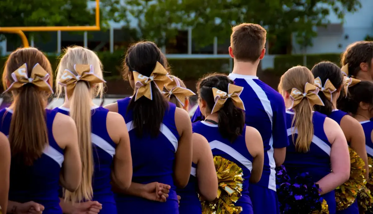 A line of students in matching school colors showing school spirit at a game