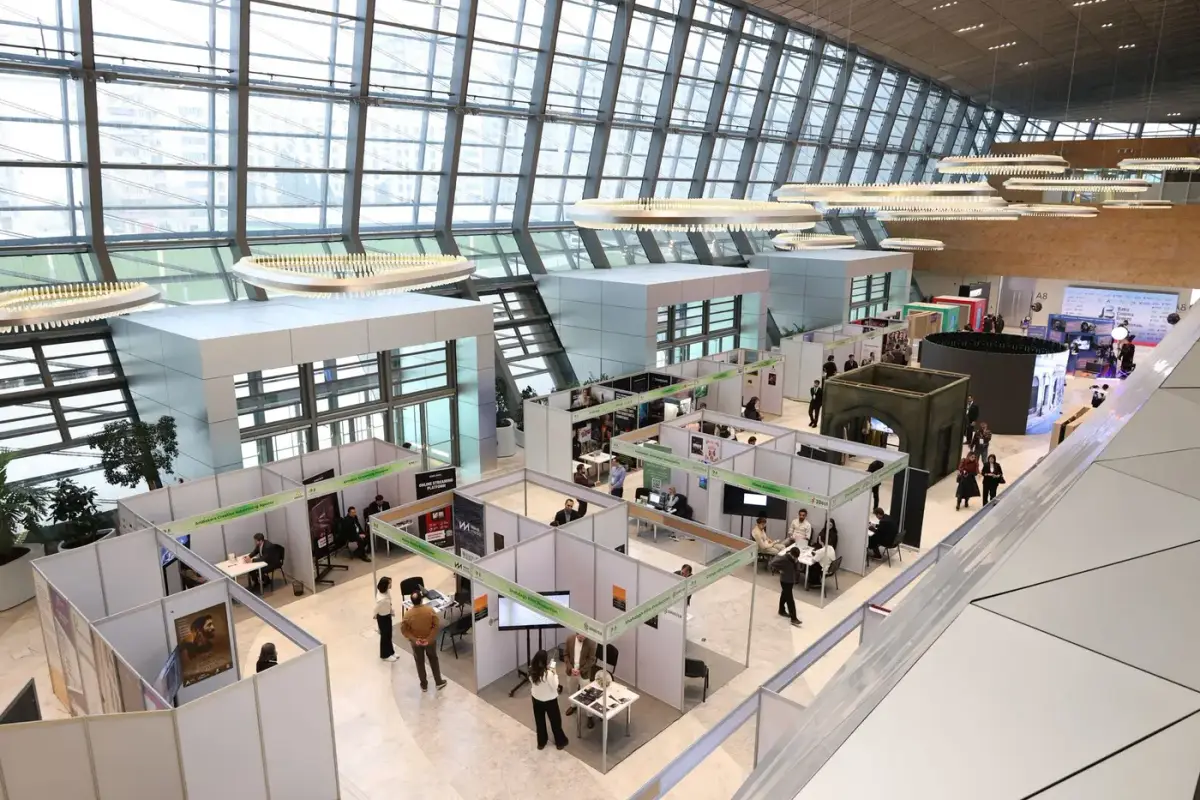 A large trade show exhibition hall filled with booths and attendees