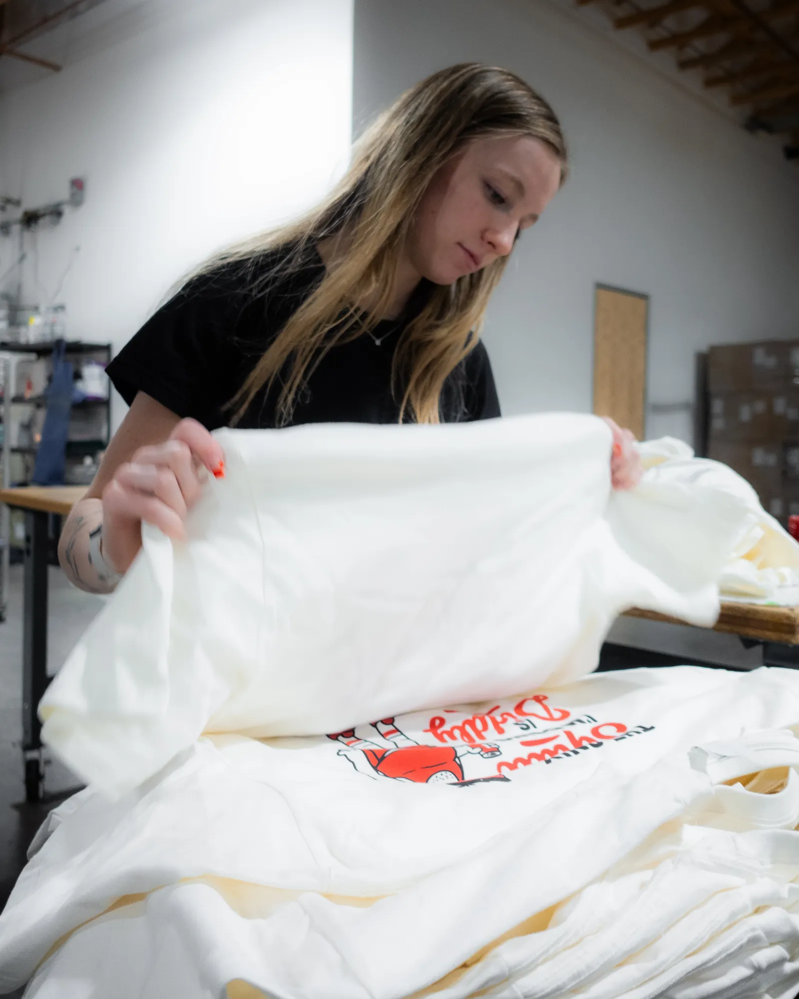 Neatly folded custom branded shirts in the Heart & Hook shop